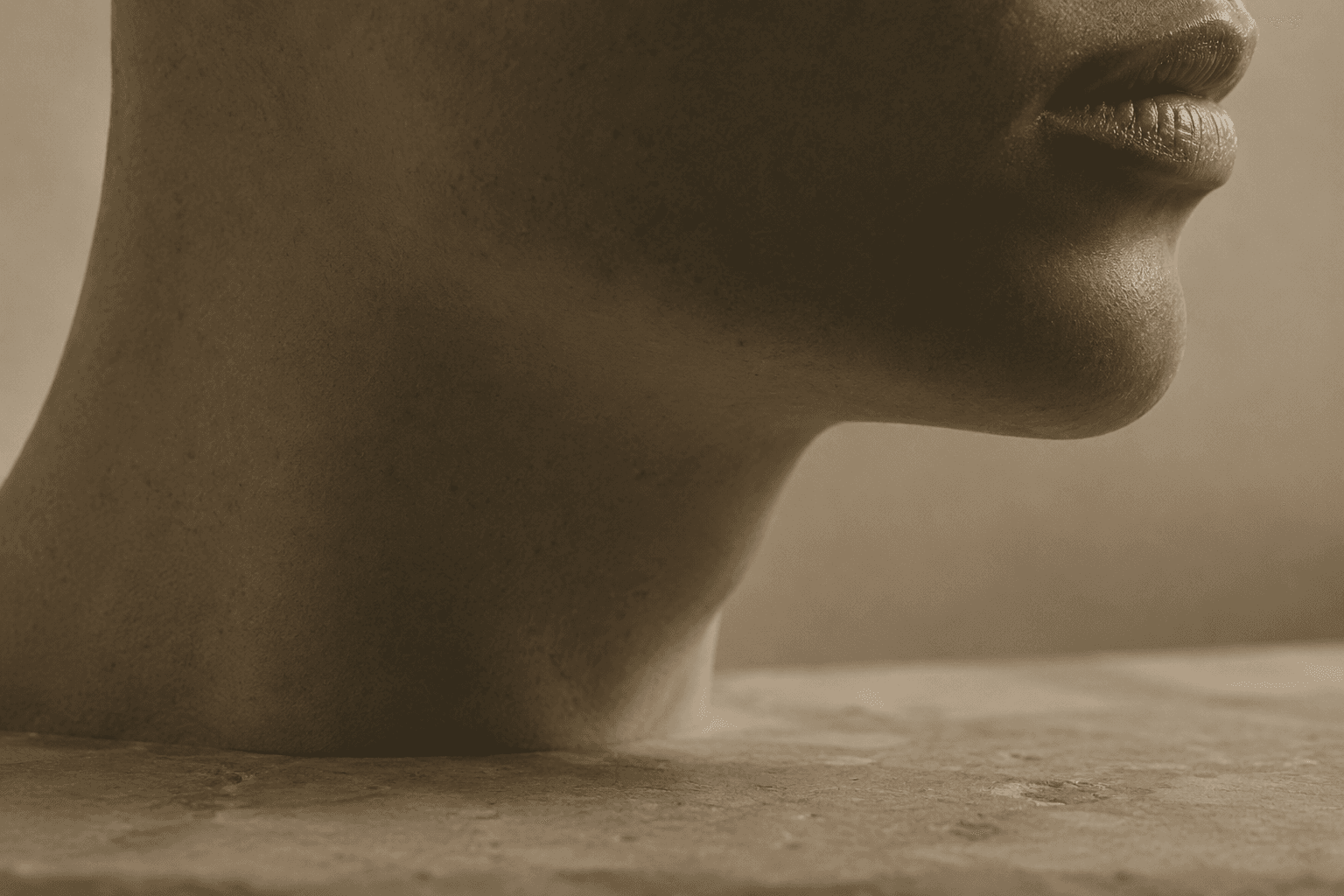 A close profile view of a jaw and neck, lit by soft raking light that traces the line of the jaw.