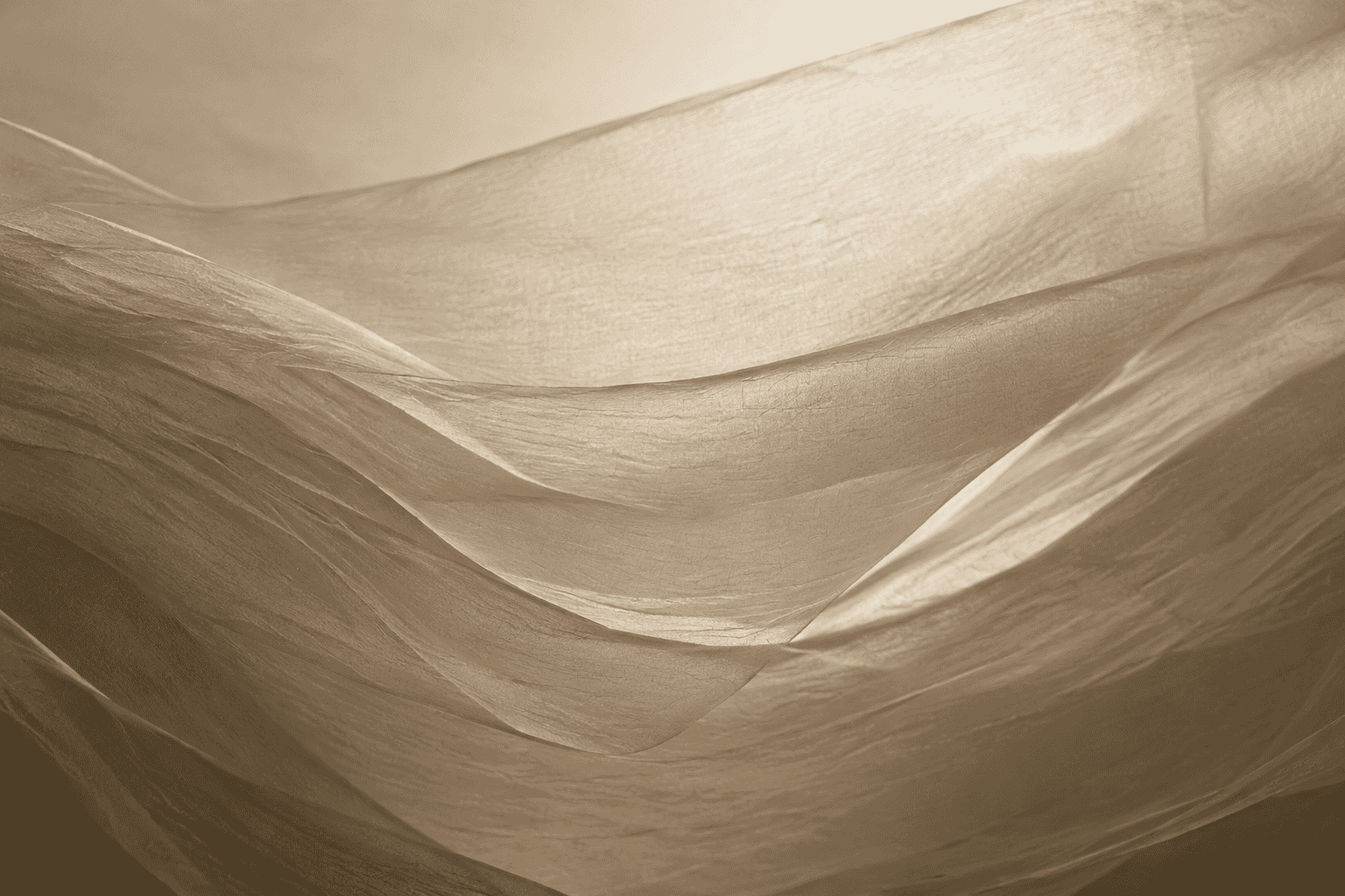 A close, textural view of pale fabric folding into soft parallel waves.
